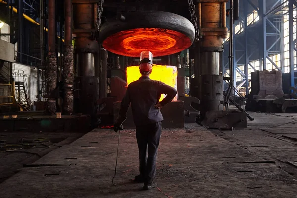 Worker blacksmith in protective clothing at the Forging shop