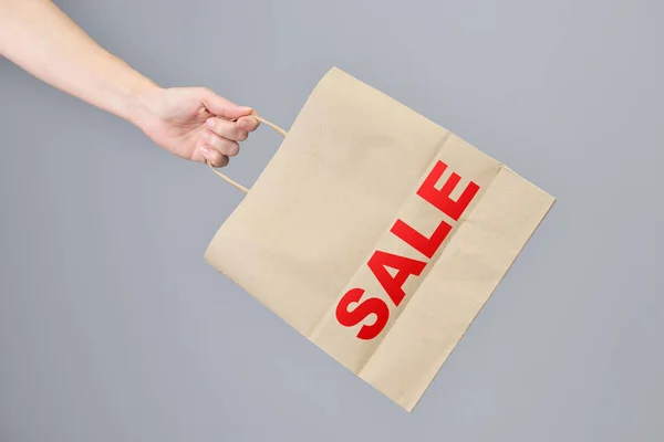 Sale- Paper shopping bag in woman\'s hand.