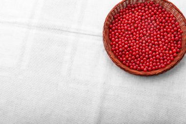 Ahşap sepet içinde taze zevkli Frenk üzümü. Gri bir arka plan üzerinde kırmızı meyveler. Renkli kırmızı kuş üzümü. Vegan gıda. 