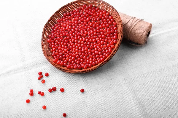 Colorful red berries on a gray background. Fresh rustic red currant in a brown basket. Vegetarian ingredient. — Stock Photo, Image