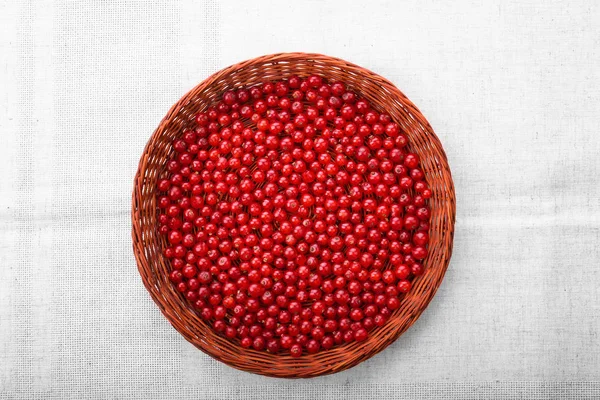 Delicious beautiful red cranberries in a wooden basket. A wooden crate on a grey background. Nutritious red currant.