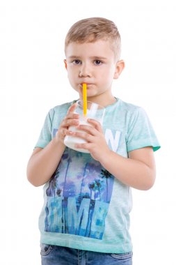 Tatlı bir çocuk sarı saçlı ve mavi bir tişört isstanding ve bir sarı saman taze ve organik süt içme beyaz bir arka plan üzerinde izole. Drinkng organik süt küçük şirin bir çocuk olduğunu.