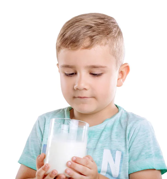 Egy imádnivaló tartja a tej, és nézi a tej az étvágy, elszigetelt fehér background. Egy szép gyermek egészséges, szerves és friss tej. — Stock Fotó