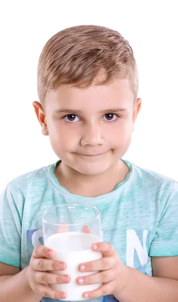 Közelkép portréja élvezetes kisfiú szőke hajat és kék póló tartja tej, és úgy néz ki, boldog, elszigetelt fehér background. Bájos kis fiú biotej. — Stock Fotó
