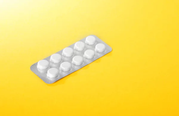 Gümüş blister hap parlak sarı bir arka plan üzerinde. Tıbbi vitaminler, haplar, Tablet. — Stok fotoğraf