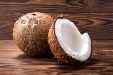 Ahşap arka plan üzerinde lezzetli tropikal Hindistan cevizi. Hawaiian kırık Hindistan cevizi kabuğu ve bütün bir deli. Sağlıklı yaşam tarzı.