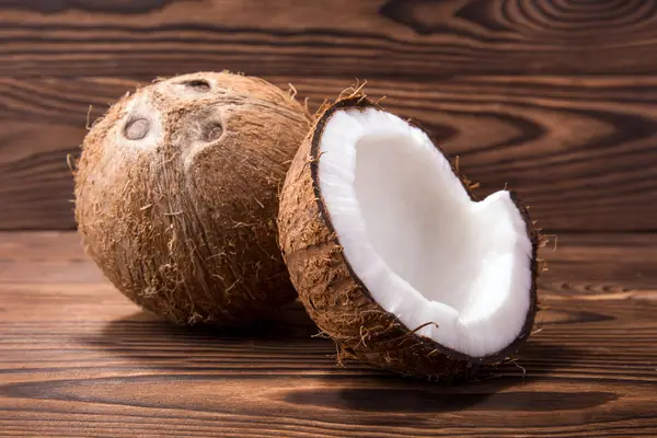 Ahşap arka plan üzerinde lezzetli tropikal Hindistan cevizi. Hawaiian kırık Hindistan cevizi kabuğu ve bütün bir deli. Sağlıklı yaşam tarzı.