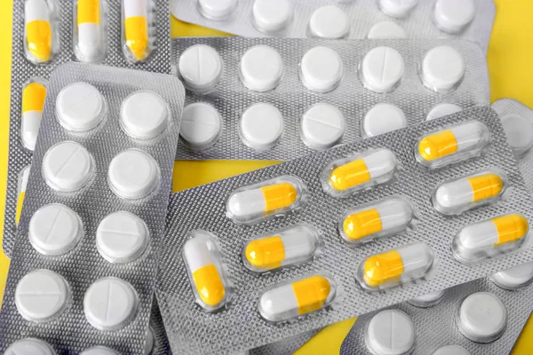 Aspirina em rodada comprimidos brancos sobre um fundo radiante. Comprimidos químicos nas bolhas. Drogas terapêuticas, antibióticos, analgésicos. — Fotografia de Stock