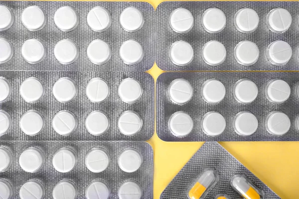 Behandlingskoncept. Närbild-vitaminer i ljus blåsor på gul bakgrund. En mängd olika medicinering. Ordinerade medicinska tabletter. — Stockfoto