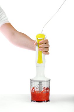 Bir blender ile parlak bir arka plan üzerinde izole çilek. Bir erkek eli taze çilek reçeli smashing. Organik yaz içecekler.