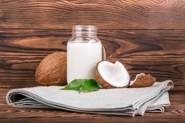 Lezzetli hindistan cevizi sütü, koyu ahşap arka plan üzerinde taze yeşil leves ile organik hindistan cevizi.