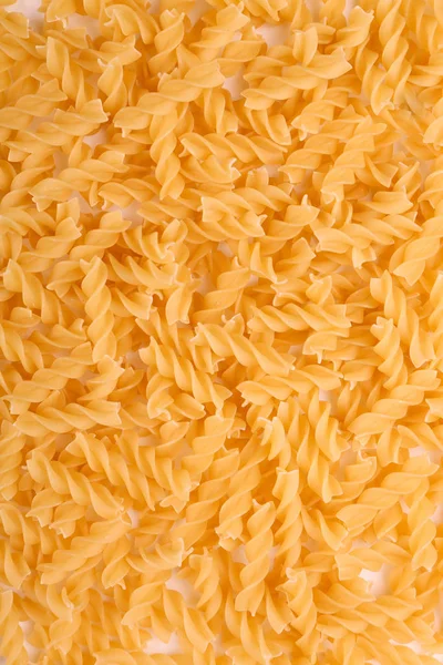 Detail makarony textury použít jako pozadí. Syrové a surové fusilli těstoviny. Typická italská jídla těstoviny. Plnoformátový suché žluté nudle. Mouku produkt. — Stock fotografie