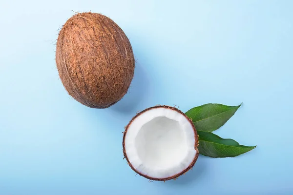 在明亮的蓝色背景上的美味椰子。新鲜的、 成熟的、 令人垂涎的椰子。一半的椰子。健康的生活方式. — 图库照片