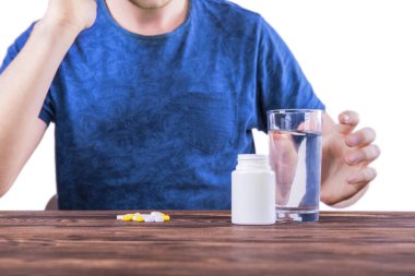 Bir migren bir adam. İntihar önleme. Beyaz bir arka plan üzerinde izole ilaç alarak bir adam. Hasta bir kadın mavi tişört '.