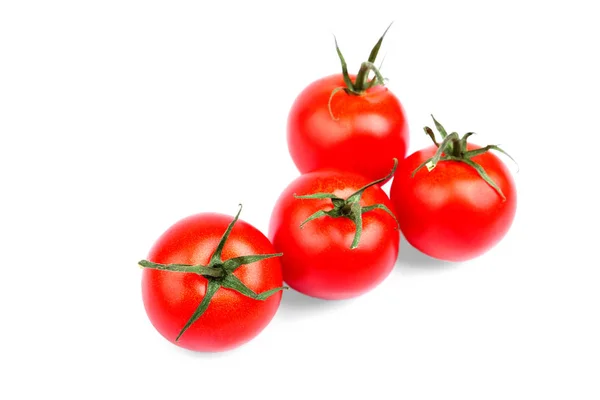 Close-up da colheita de verão de tomates vermelhos brilhantes com folhas verdes isoladas em um fundo branco. Tomates suculentos, maduros e frescos. Produtos hortícolas saudáveis . — Fotografia de Stock