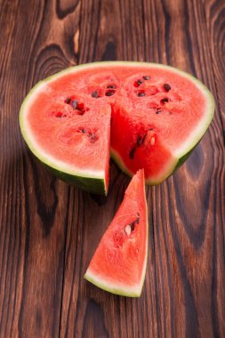 Bir yarı ahşap arka plan üzerinde bir karpuz. Tatlı, tatlı, ham ve olgun karpuz close-up. Canlandırıcı yaz meyve. 