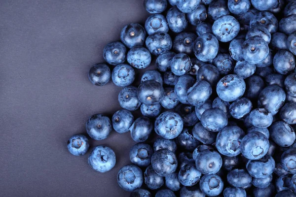 A top view of juicy blueberries. Fresh blueberries on a dark background. Sweet and tasty berries. Ingredients for healthy snacks.