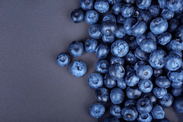 Una vista superior de jugosos arándanos. Arándanos frescos sobre un fondo oscuro. Bayas dulces y sabrosas. Ingredientes para bocadillos saludables . — Foto de Stock