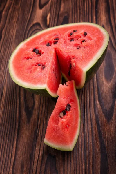 Media sandía sobre un fondo de madera. Un primer plano de una sandía dulce, fresca, cruda y madura. Frutas refrescantes de verano . — Foto de Stock
