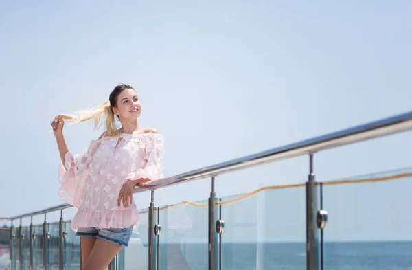 Een lachende, aantrekkelijk en gelukkige vrouw is genieten van zonnige zomer. Het schattige model meisje op een heldere blauwe hemelachtergrond. — Stockfoto