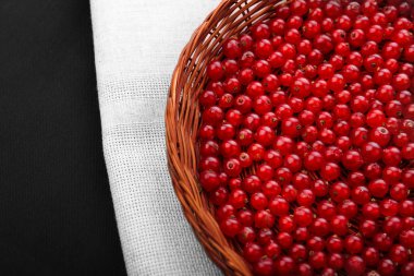 Ham Frenk üzümü gri bir çanta ve bir arka plan siyah yakın çekim. Ahşap sepet içinde kırmızı lezzetli meyveler. Vejetaryen kahvaltı için organik çilek.  