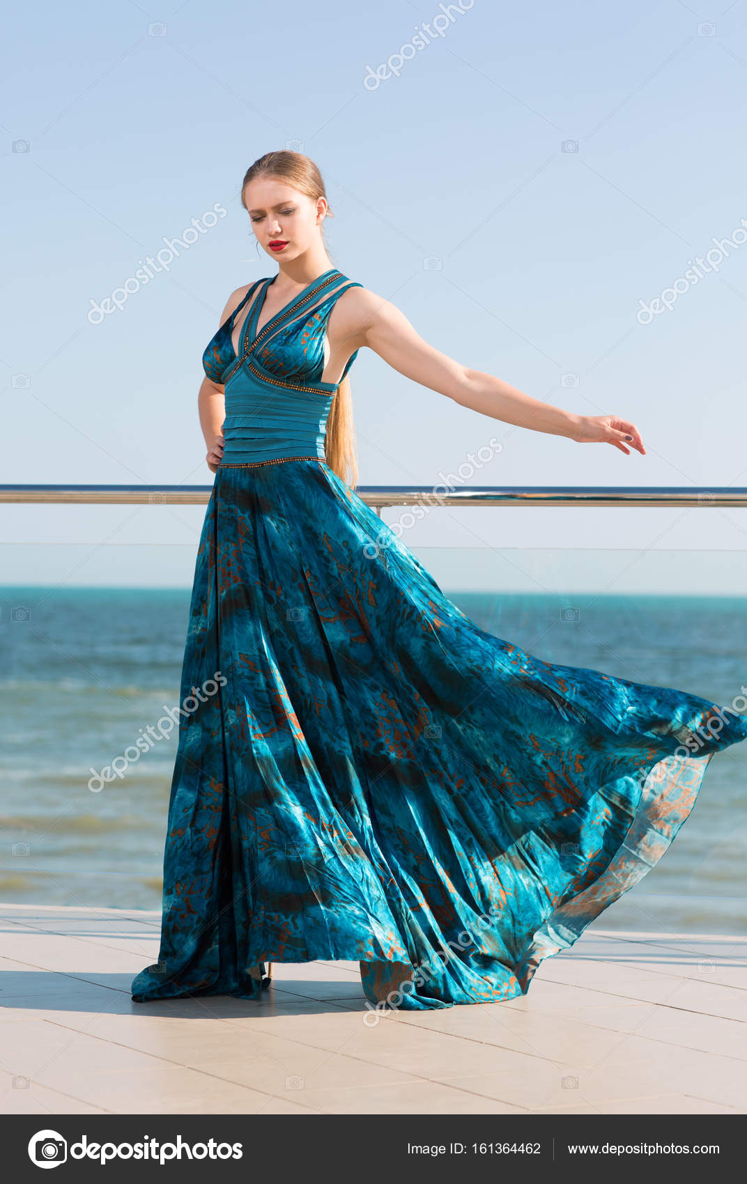 An Elegant Lady With Long Blonde Ponytail And In A Long Waving Emerald Dress Posing Near A Blue Sea The Beautiful Girl On Vacation On The Sea Stock Photo By C Alfa4studio