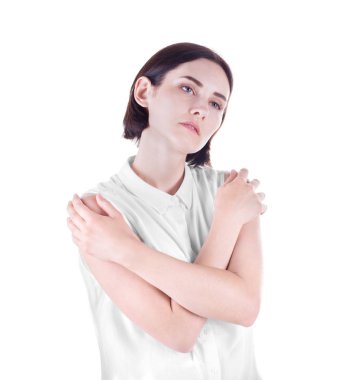 Beyaz bir arka plan üzerinde izole üzgün bir kadın. Bir ihale kadın kendini sarılıyor. Bir düşünceli ve güzel kız siyah saçlı.