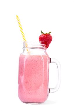 Güzel pembe milkshake sarı çizgili pipet ve sevimli kırmızı çilek üstüne bir cam kavanoza. 