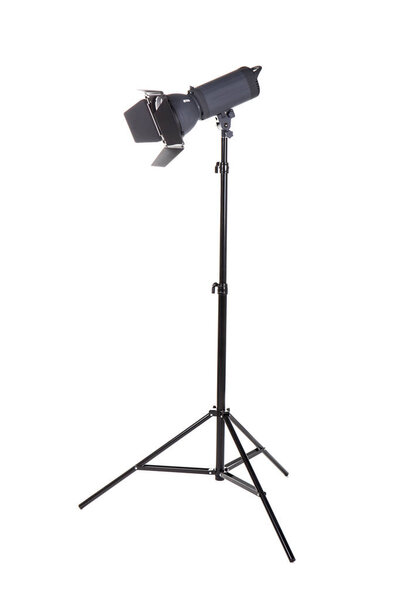 Studio flash isolated on a white background. Photo-studio with lighting equipment. Modern powerful photographic flash. Professional equipment. Studio photography video light. A long tripod.