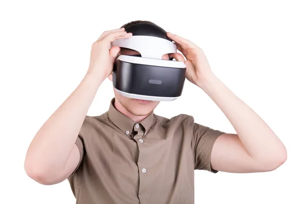 Um jovem com capacete de realidade virtual, isolado num fundo branco. Ação do homem em óculos de realidade virtual. Óculos VR . — Fotografia de Stock