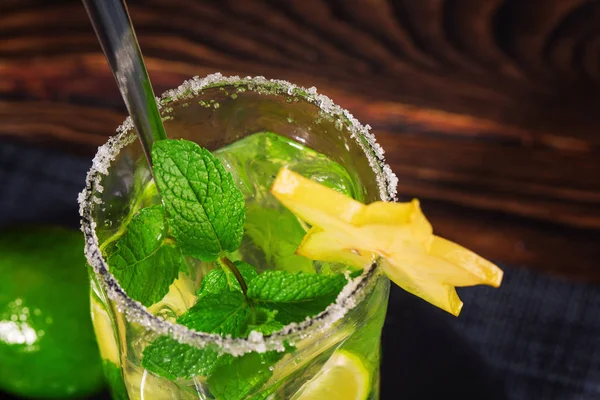 Draufsicht auf einen frischen Sommer-Mojito-Cocktail in einem transparenten Highball-Glas mit einem langen Teelöffel auf dem Holztisch. Kopierraum. — Stockfoto