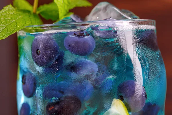 在木制背景下 蓝莓和薄荷叶的鲜蓝色饮料的关闭 — 图库照片