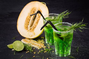 Soğuk alkol kokteyller. İki bardak tarhun ile yeşil içecekler. Tatlı limon ve Ekşi limon kesilmiş. Alkollü yaz kokteylleri.