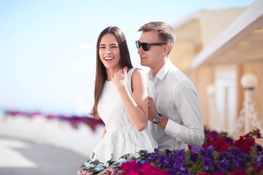 Bir çift bir tatil. Güneşli kıyı arka plan güzel lovers. Çok güzel bir kız ve gülümseyen bir erkek. Kopya alanı.