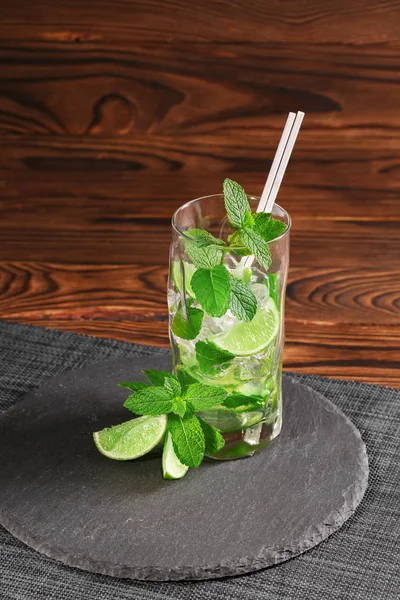 Kalter Mojito mit Eis und Kalk. Grüner Mojito mit Rum oder Likör auf Holzgrund. Erfrischende alkoholische Getränke. Kopierraum. — Stockfoto
