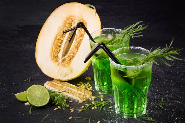 Soğuk alkol kokteyller. İki bardak tarhun ile yeşil içecekler. Tatlı limon ve Ekşi limon kesilmiş. Alkollü yaz kokteylleri.