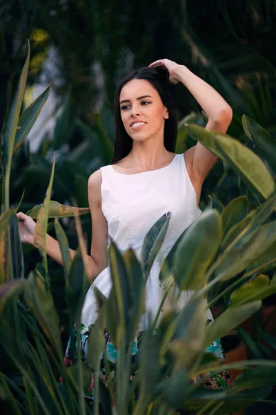 Une femme belle et souriante. Une jeune femme réfléchie. Une fille en robe blanche sur un fond vert de parc d'été. Une fille sensuelle . — Photo