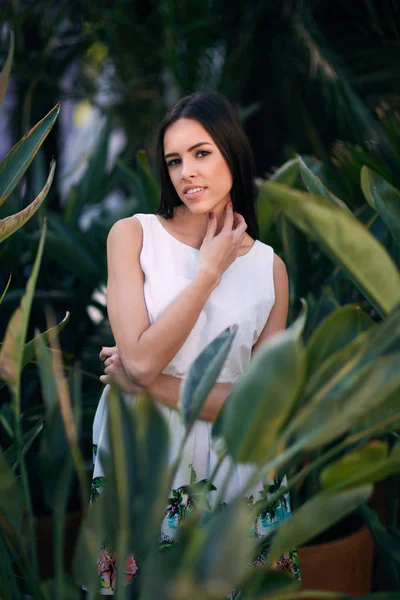 Une femme belle et souriante. Une jeune femme réfléchie. Une fille en robe blanche sur un fond vert de parc d'été. Une fille sensuelle . — Photo