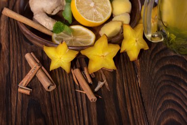 Ekşi limon ve kahverengi güzel kokulu kesilmiş bir parlak sarı carambola ve yakın çekim bir ahşap zemin üzerine tarçın. Sağlıklı çay maddeler.