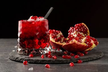 Lezzetli, taze sıkılmış nar suyu buz küpleri siyah bir arka plan ile. RIPE, sulu, organik ve parası garnet meyve. Sağlıklı yaşam tarzı.