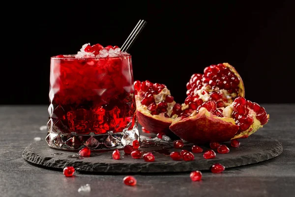 Välsmakande, färskpressad granatäpplejuice med isbitar på svart bakgrund. RIPE, saftiga, ekologiska och nytta garnet frukt. Hälsosam livsstil. — Stockfoto