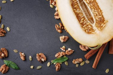 Kompozisyon kesme kavun, ceviz ve tarçın. Tatlı meyve ve gevrek fındık tablo arka plan üzerinde. Vejetaryen yiyecekler. Kopya alanı.