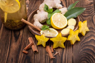 Top kahverengi ve Ekşi limon kokulu kesilmiş bir parlak sarı carambola görünümünü bir ahşap zemin üzerine tarçın. Sağlıklı çay maddeler.