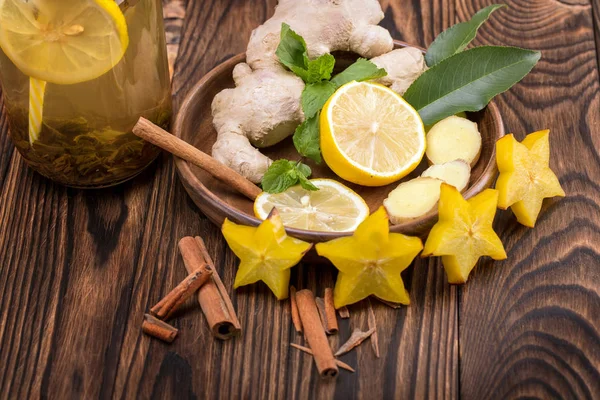 Top kahverengi ve Ekşi limon kokulu kesilmiş bir parlak sarı carambola görünümünü bir ahşap zemin üzerine tarçın. Sağlıklı çay maddeler.