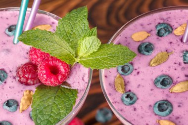 Ahşap arka plan üzerinde gözlük pembe içecekler tam bir görünümü yukarıdaki. Tatlı kahvaltı için organik smoothies.