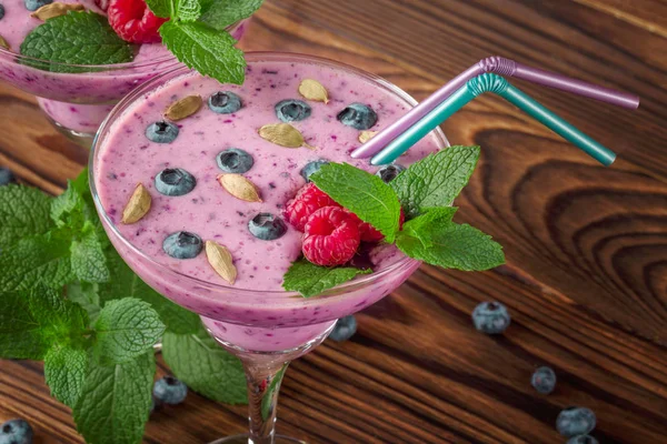 Une vue d'en haut de verres pleins de boissons roses sur un fond en bois. Smoothies bio pour petits déjeuners sucrés . — Photo