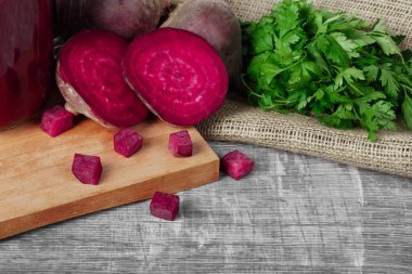 Bütün ve dilimlenmiş beetroots, maydanoz ve içecek bir kesme tahtası ve ahşap arka plan. Bir bahçe sebze.