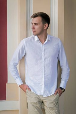 El HIPS üzerinde şık adam. Odaklı adam dışında. Bir erkek bir binanın zemin üzerine yaz giysileri. İş kavramı.