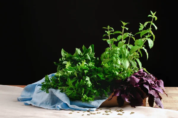 Belo conjunto de verduras. Folhas de salada recentemente escolhidas, salsa e casa da moeda em uma mesa em um fundo preto. Tigela de saladas . — Fotografia de Stock