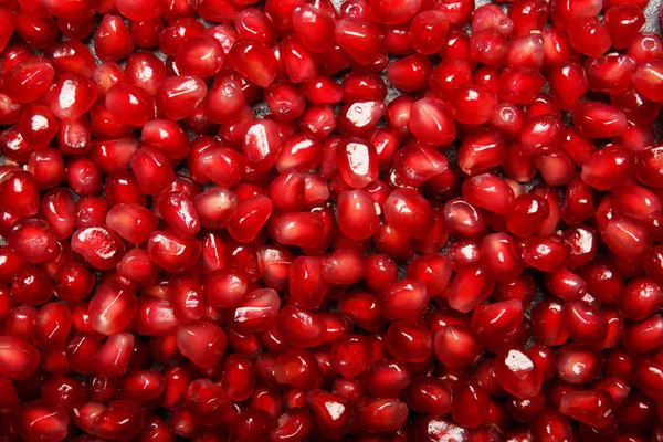 Granathintergrund. Granatapfel-Hintergrund. saftige rote Granatapfelkerne. natürliche fruchtige Zutaten für gesunde Säfte. — Stockfoto
